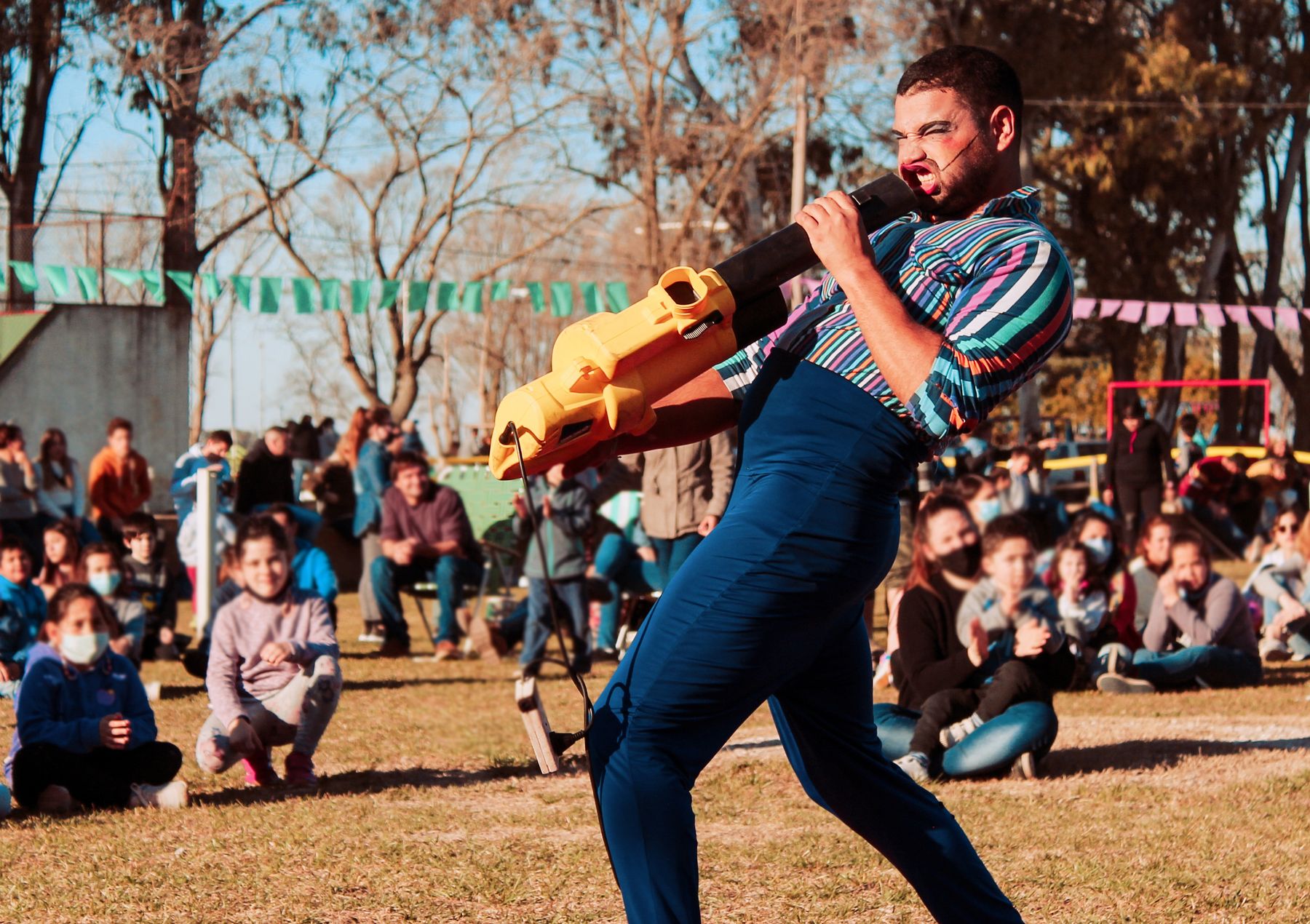 A colourful performer entertaining families at an outdoor event